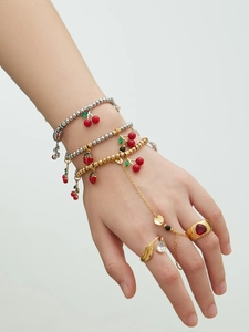 Détail du bracelet à breloques cerise et coccinelle avec bague en pierre en forme de cœur