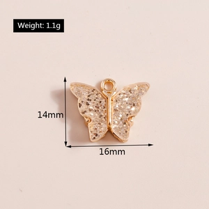 Detail of a 14x16mm butterfly charm featuring golden glitter and a metallic frame