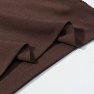 Détail du tissu en maille côtelée marron foncé montrant texture et élasticité de la robe