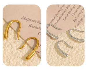 Détail des boucles d'oreilles en forme de U en finitions métalliques or et argent