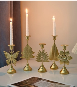 Detailed view of gold metal butterfly and tree candle holders with white spiral candles