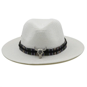 Detail of white straw fedora with ethnic band and vintage metal bull head ornament