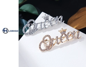 Vue macro des broches Queen dorées et argentées avec strass et détails de couronne