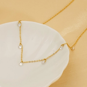 18k gold plated stainless steel necklace with zircon crystals in a shell dish