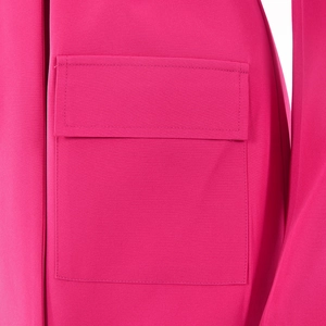 Détail d'une poche à rabat carrée sur un blazer magenta avec texture du tissu