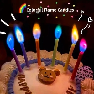 Close-up of vibrant multi-colored flames on birthday candles with holders on cake