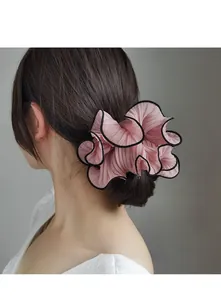 Detail of pink chiffon scrunchie with black edges and accordion pleats on model hair