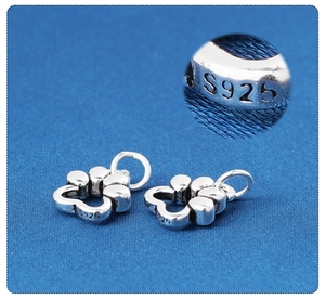 Macro shot of S925 sterling silver paw pendant showing authentic certification stamp