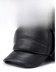 Close-up of black leather flat cap showing detailed pebble grain texture and neat stitching