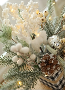Close-up of festive Christmas pine branch arrangement with LED lights and deer decor