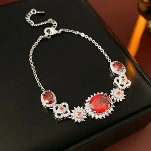 Detailed close-up of a silver flower bracelet with a large oval red zircon centerpiece