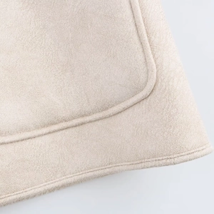 Macro view of beige faux suede fabric texture with precision stitching details on the coat