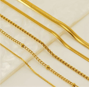 Macro shot of 18K gold plated 304 stainless steel chain styles on white marble