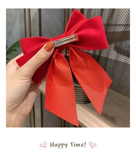 Close-up of large red satin bow hair clip with sturdy metal duckbill clip for girls