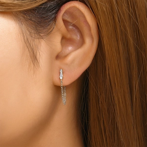 Close-up of 925 silver pearl drop earrings with crystal tassels on a female model