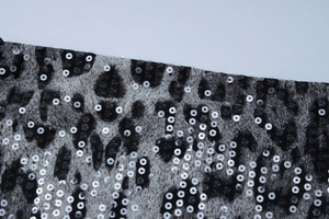 Macro shot of leopard print dress fabric with shimmering silver sequins and textures