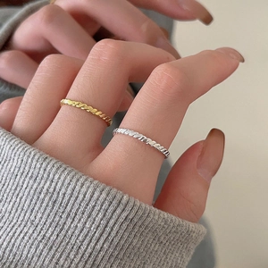 Close-up of gold and silver twisted rope rings on a model for a stylish layered look
