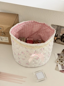 Macro shot of quilted floral fabric organizer box with lace trim and pink ribbon bow
