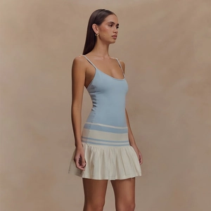 Détail de la robe moulante avec haut en maille bleu clair et jupe courte plissée blanche