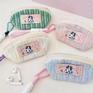 Détail de mini pochettes écouteurs tricotées avec motifs de dessin animé et mousquetons