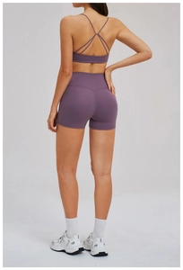 Detail of purple yoga set showing thin cross-back straps and high-waisted gym shorts