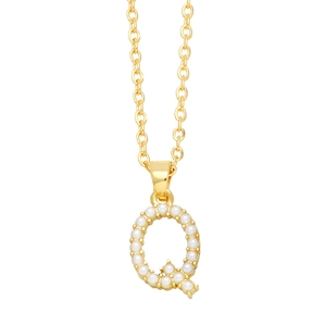 Close-up of gold initial Q necklace pendant featuring elegant inlaid white pearls