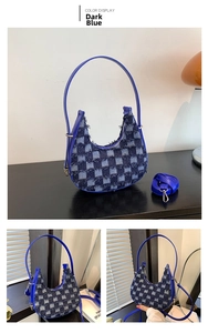 Detail of dark blue denim checkerboard crescent bag with frayed edges and leather strap