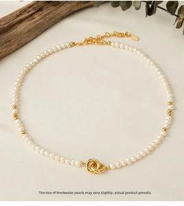 Macro detail of natural freshwater pearls and interlocking gold rings on a chic necklace