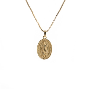 Macro view of gold necklace with engraved Our Lady of Guadalupe oval pendant and zircons