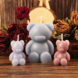 Detailopname van kleine beervormige geurkaarsen in blauw en roze op een rustieke houten tafel