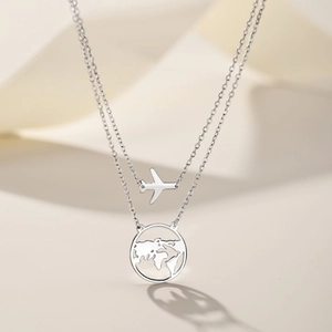 Close-up of S925 sterling silver layered necklace with airplane and earth pendants