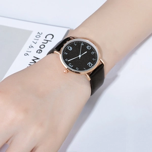 Detail of slim quartz watch with rose gold case and black glitter dial on female wrist