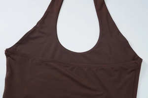 Detailaufnahme des braunen Halterneck-Tops mit elastischer Stoffstruktur und feinen Nähten