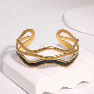 Détail d'un bracelet jonc plaqué or 18k avec motif vagues noires sur support