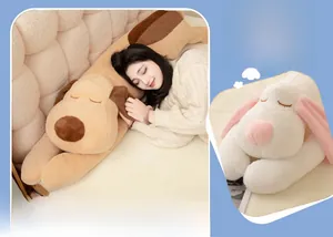 Close-up of soft plush dog bolster pillows in brown and pink colors on a bed