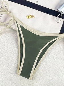 Detail of olive green bikini bottom with side ties and golden wing metal decoration