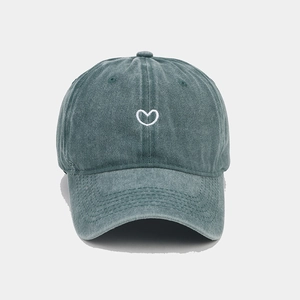 Detail shot of vintage washed green canvas baseball cap with white heart embroidery
