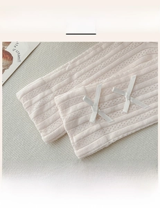 Detail of pink ribbed mid-calf socks with cute white ribbon bows and elastic cuffs