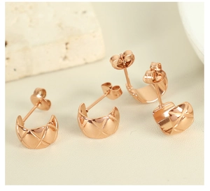 Macro shot of rose gold C-shaped earrings with elegant quilted lattice texture details