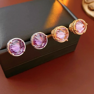 Detailed close-up of 18k gold and silver plated earrings with purple zircon crystals