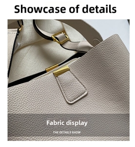 Detalle de la textura de cuero granulado y hebilla de metal dorado mate en bolso beige