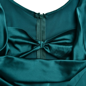Détail de la robe en satin vert foncé montrant la fermeture éclair invisible et le nœud