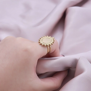 Detail of vintage oval gold signet ring with sunburst texture on purple silk fabric
