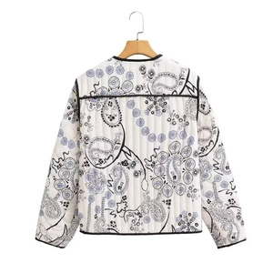 Detail view of white quilted jacket with black paisley pattern and contrast piping