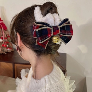 Detail of Christmas reindeer antler hair claw clip with plush white fur and festive bow