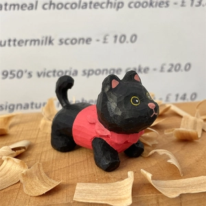 Gros plan d'une figurine de chat noir en bois sculpté à la main avec texture