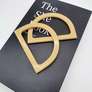 Macro view of two polished beige resin D-shape handles for DIY knitted handbags