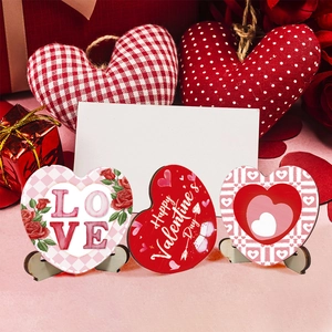 Detail of three romantic Valentine's wooden heart signs with floral patterns and stands