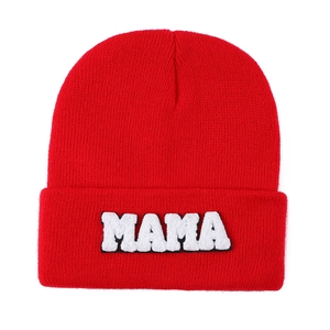 Detailed knit texture of red beanie featuring white MAMA towel embroidery patch