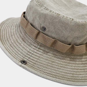 Detailed macro view of washed cotton fabric texture and metal button on khaki sun hat
